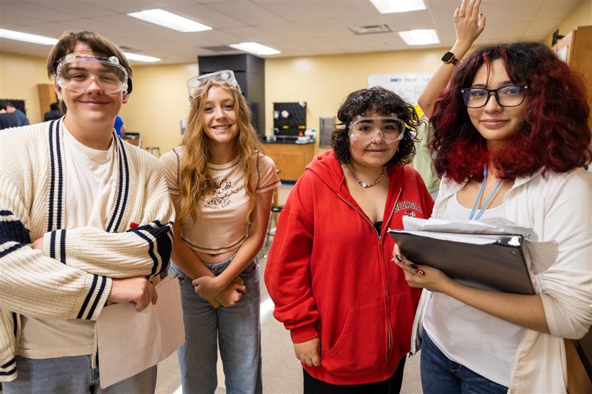 Four students stand in a chemistry lab